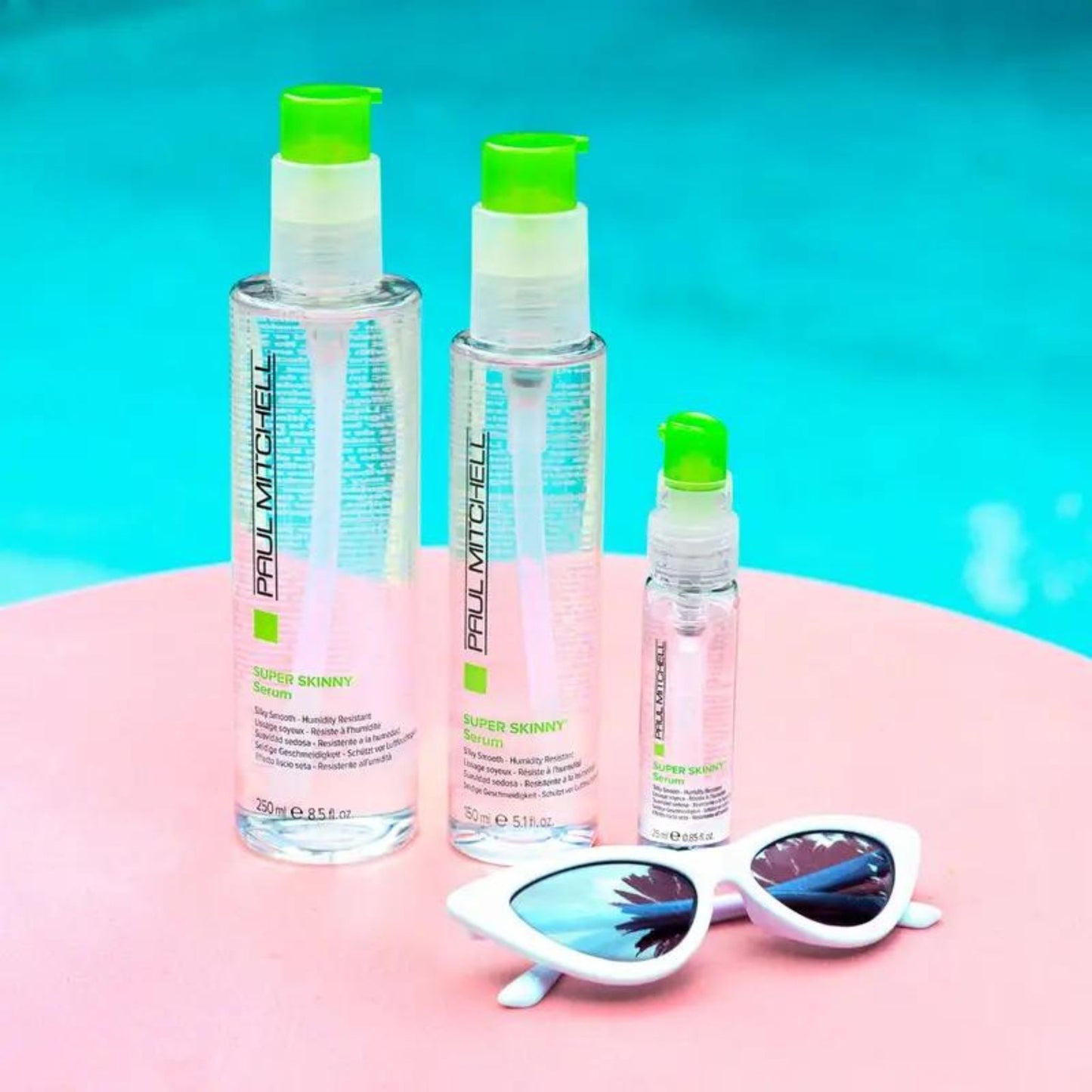Super Skinny Serum - SB all serum sizes displayed next to cat eye sunglasses on pink surface.